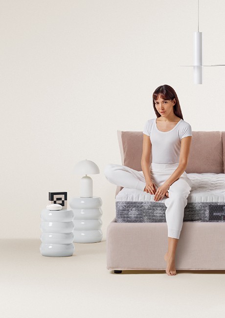 Wellbeing recharge - woman sitting on top of Magniflex mattress